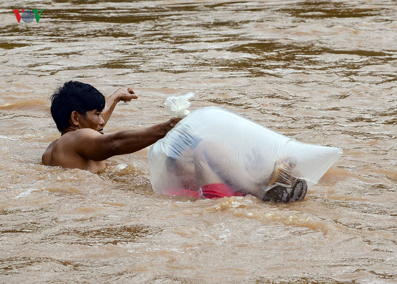 Estudantes são transportados em sacos em rio para não se molharem 04